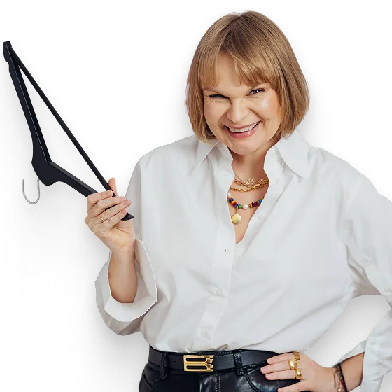 Monika Jurczyk OSA w białej koszuli, uśmiechnięta, z czarnym wieszakiem w dłoni